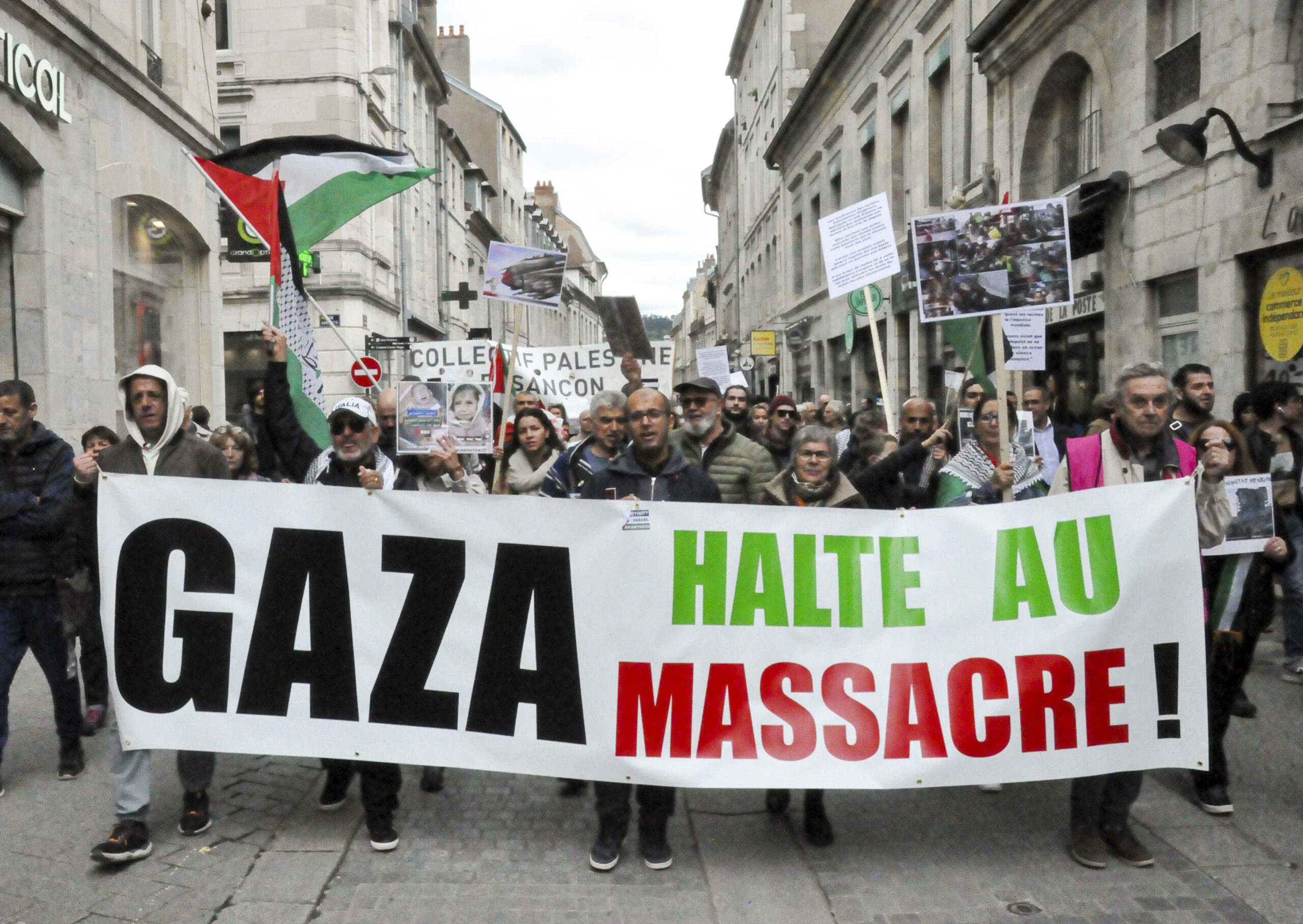 Tête de la manifestation en soutien au peuple palestinien. Les participantes et participants tiennent une large banderole où il est écrit en noir vert et rouge : "Gaza, halte au massacre."