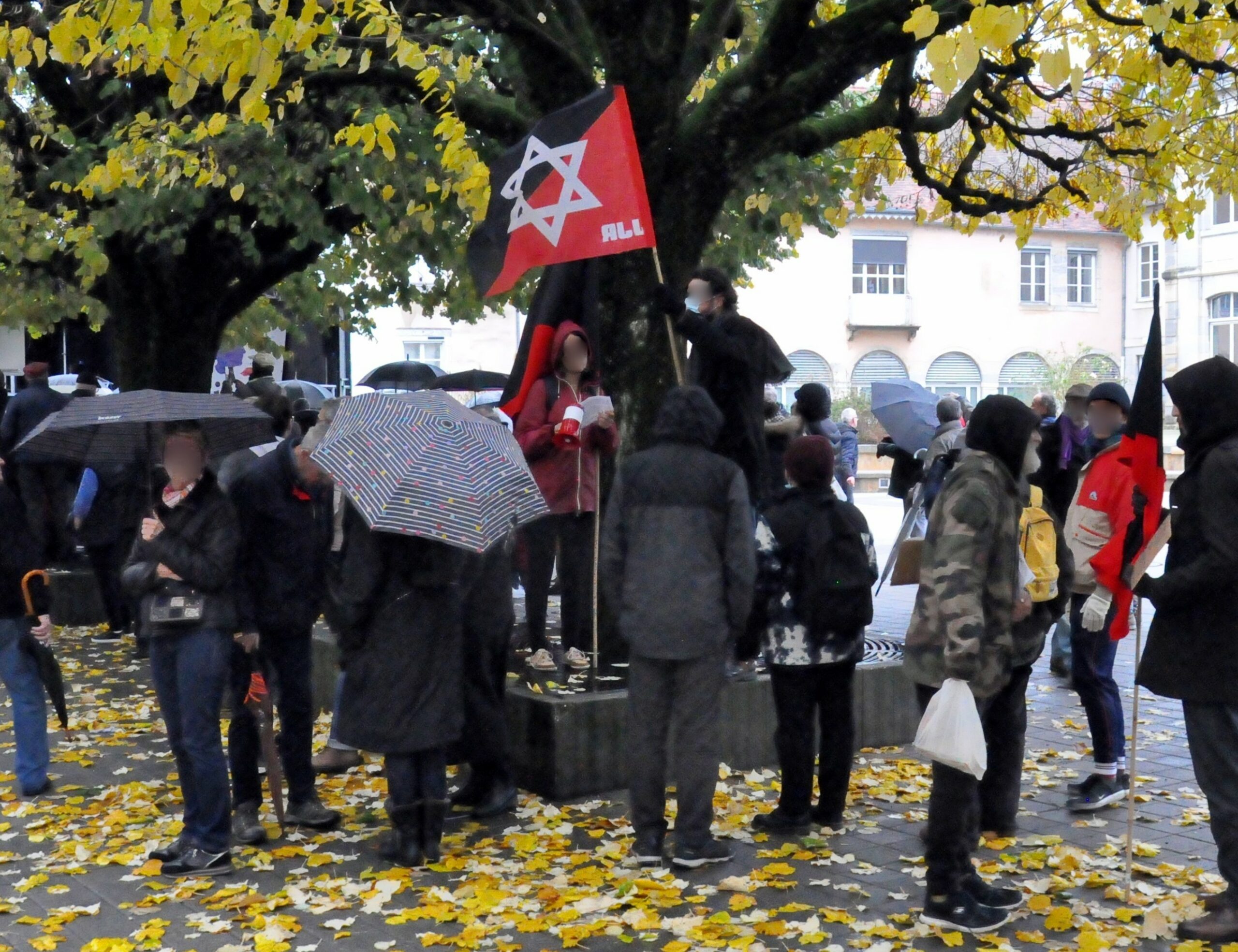 Une dizaine de Juifs Révolutionnaires participent à une marche contre l’antisémitisme, avec drapeau rouge et noir frappé de l’étoile de David.