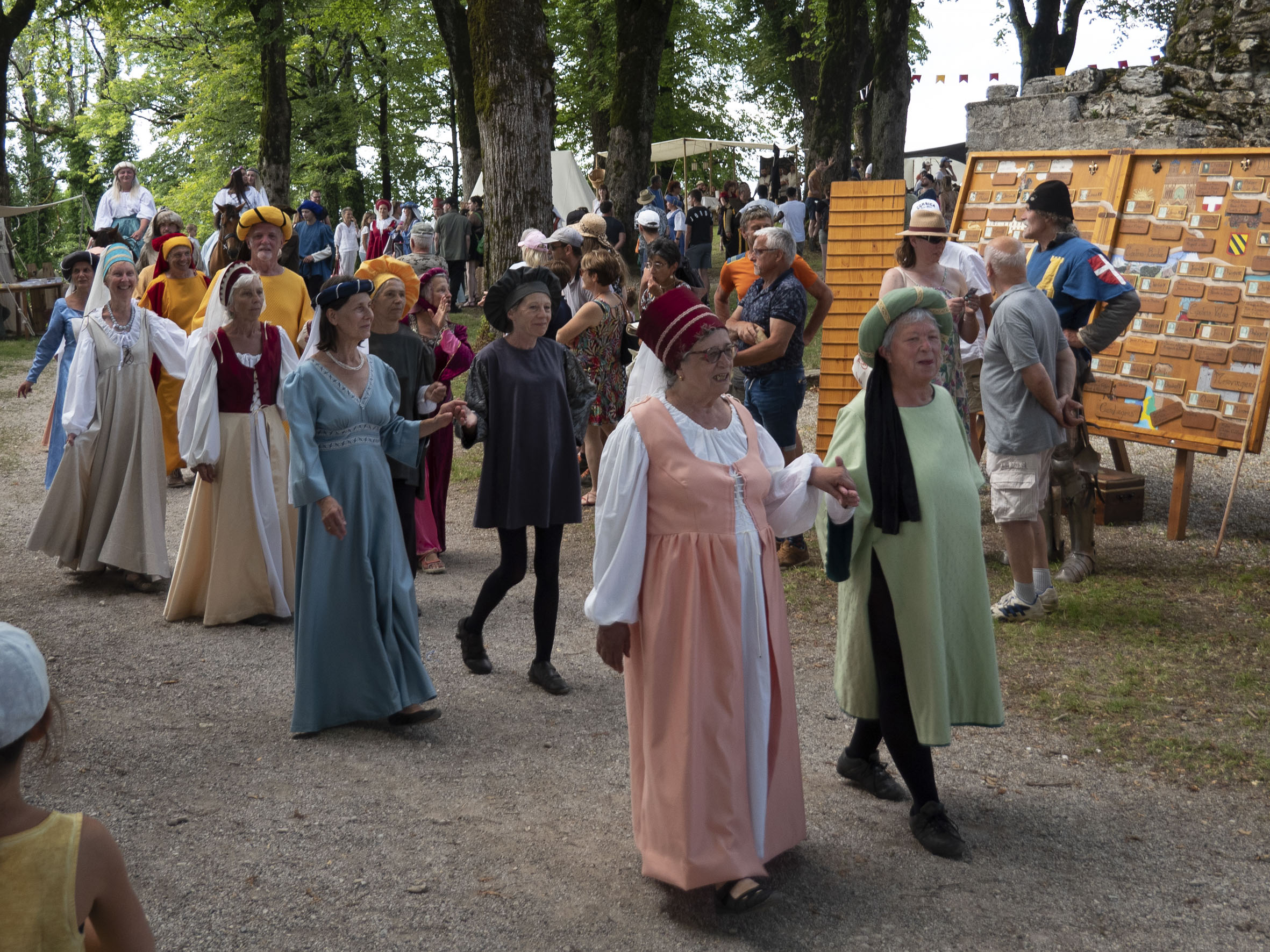 procession de femmes habillées en dames de la cour, le long des stands