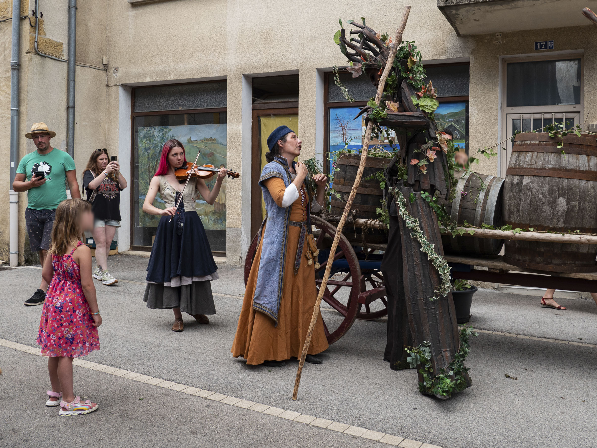 spectacle de rue, avec une violoniste et une femme perchée sur échasses et costumée en arbre