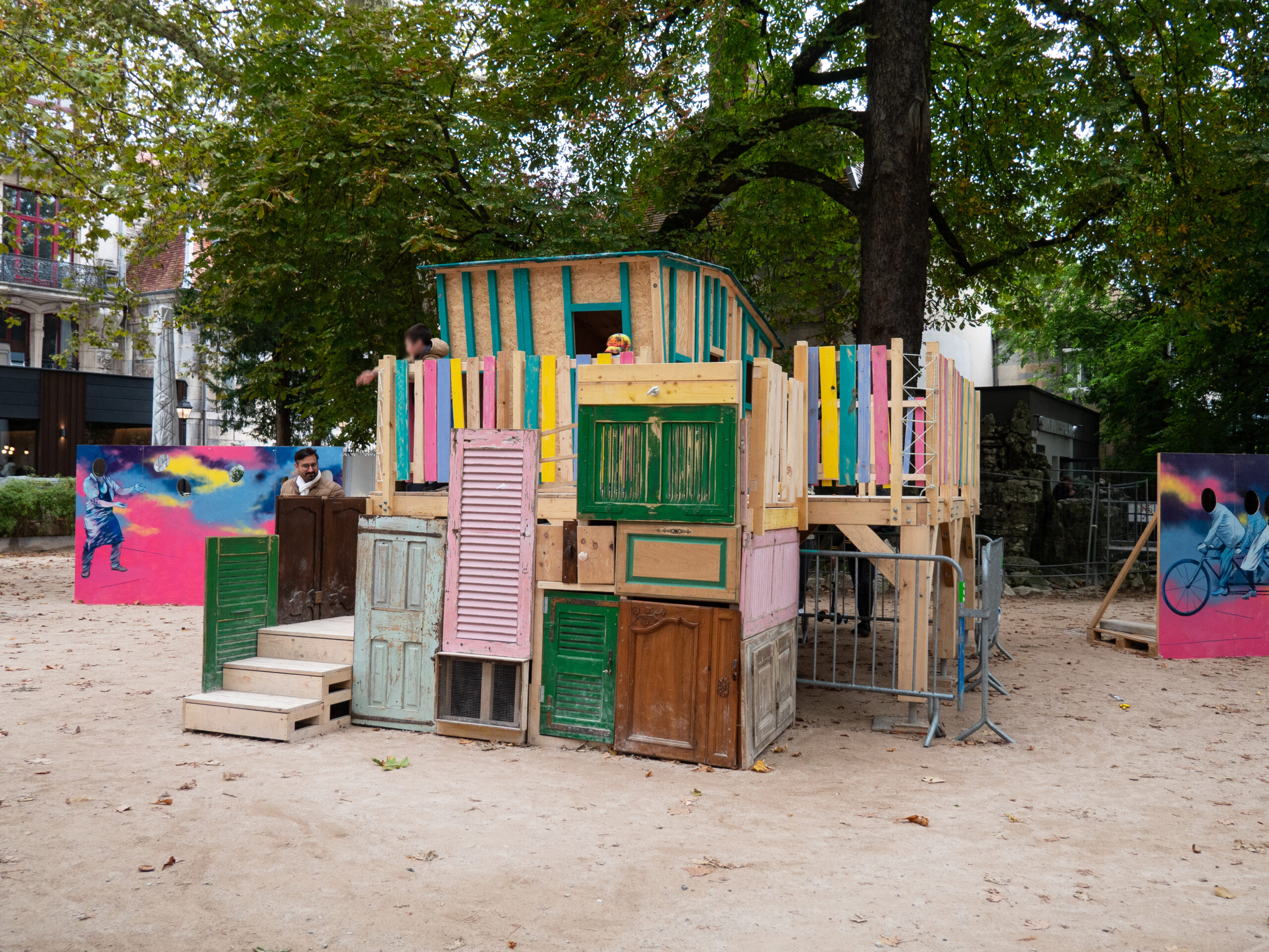 Structure de jeux pour enfants installée à Granvelle, faite de portes et volets colorés bricolée autour d'une ossature en bois de récupération 