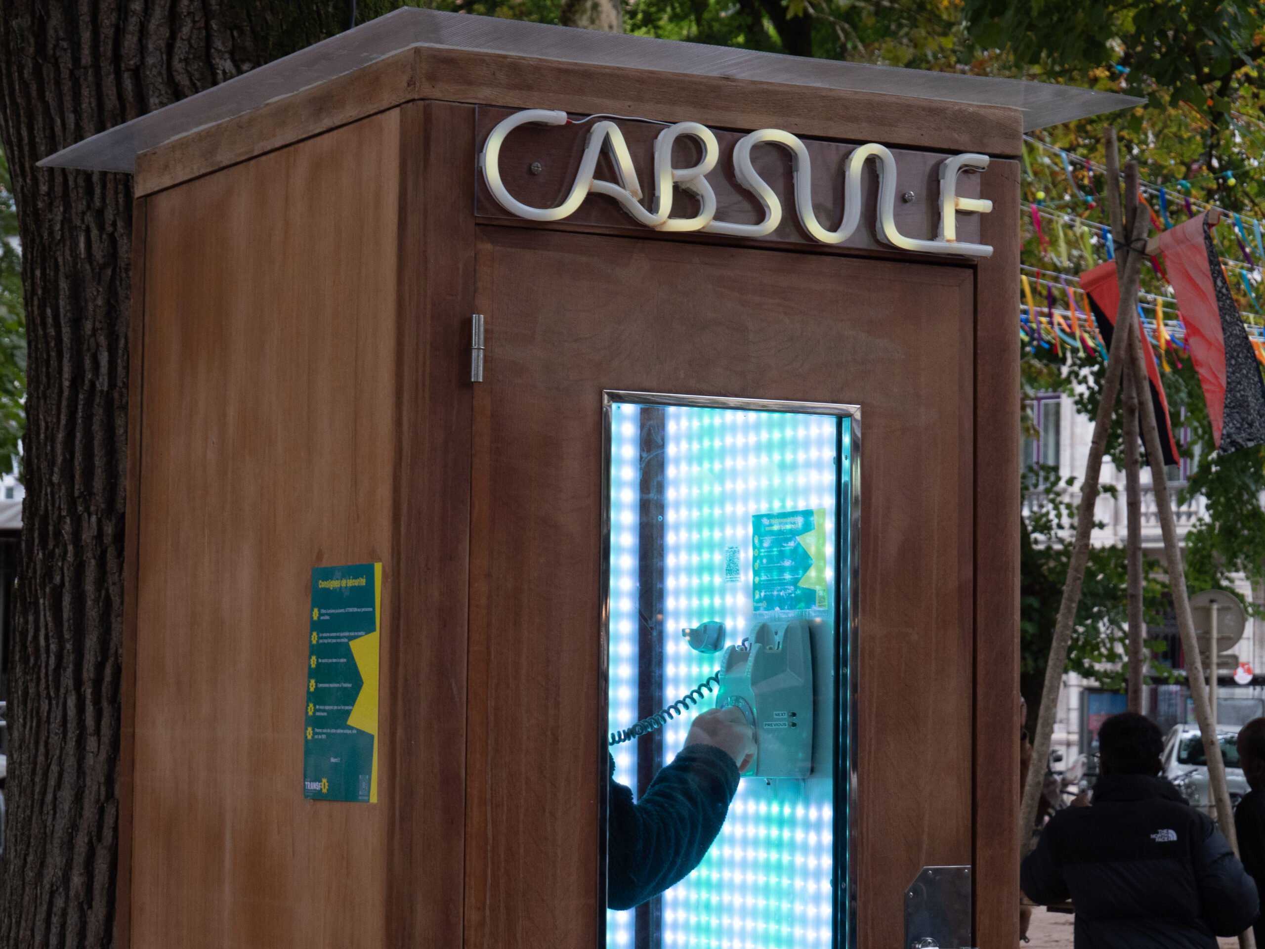 Photo d'une capsule ressemblant à une cabine téléphonique en bois, dans laquelle on pouvait entendre le tube musical de son année de naissance