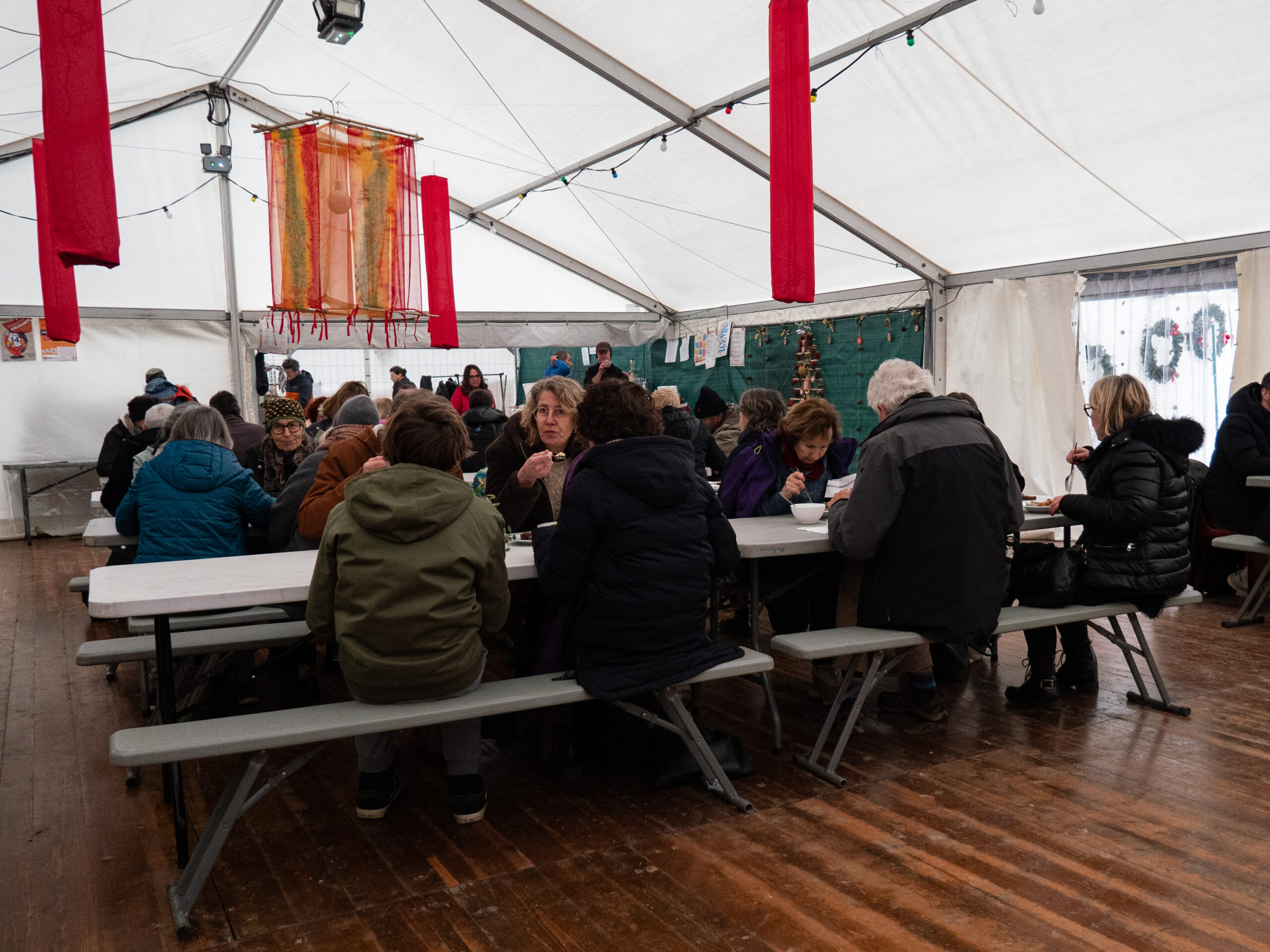 le coin restauration, à un bout du chapiteau blanc où ont été dressés des tables et des bancs de camping