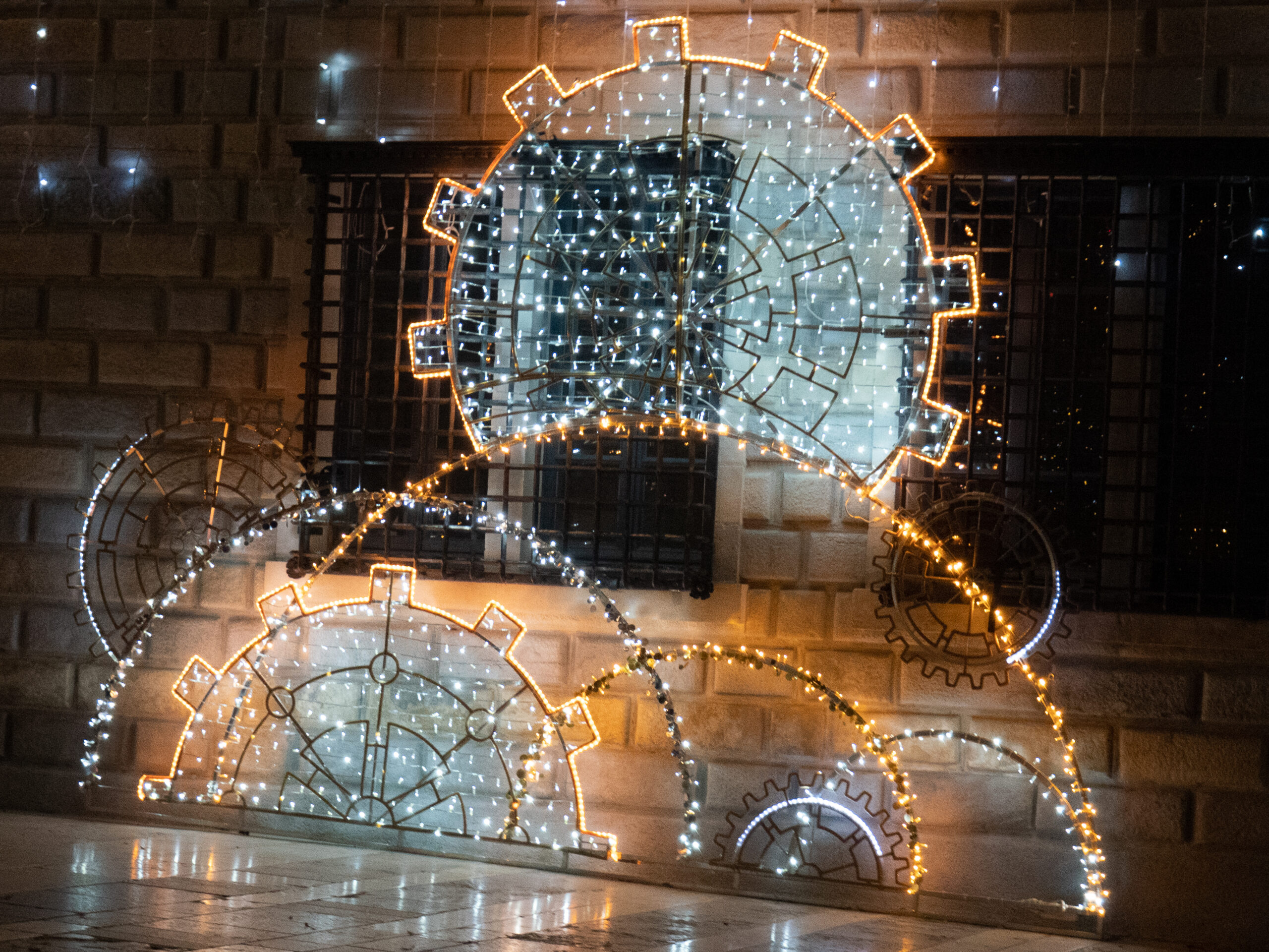 l'installation lumineuse sur la place du 8 septembre, représentant des rouages de montre faisant penser à l'agencement des flocons de neige, lumière à dominante jaune et bleue