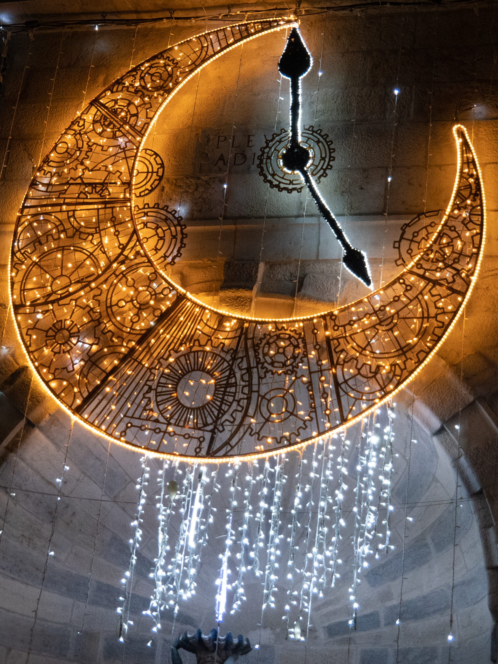 Une horloge lumineuse installée place du 8 septembre, donc le cadre est un croissant de lune jaune de laquelle pendent quelques guirlandes bleues