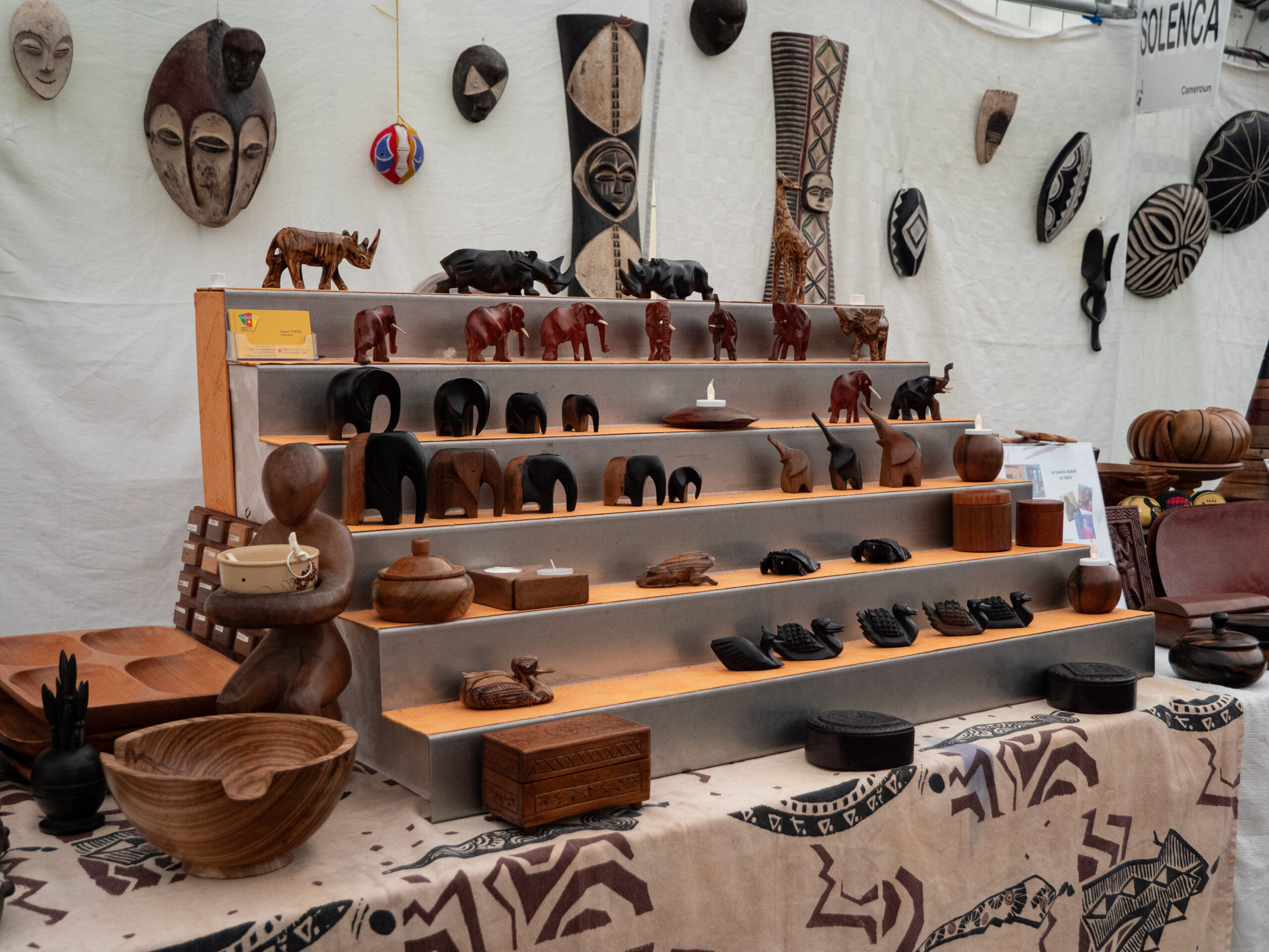 Sculptures en bois représentant des éléphants, canards, grenouilles ou rhinocéros, avec également quelques poteries et boites artisanales, vendues au profit de l'association Solenca (Solidarité enfance Cameroun)