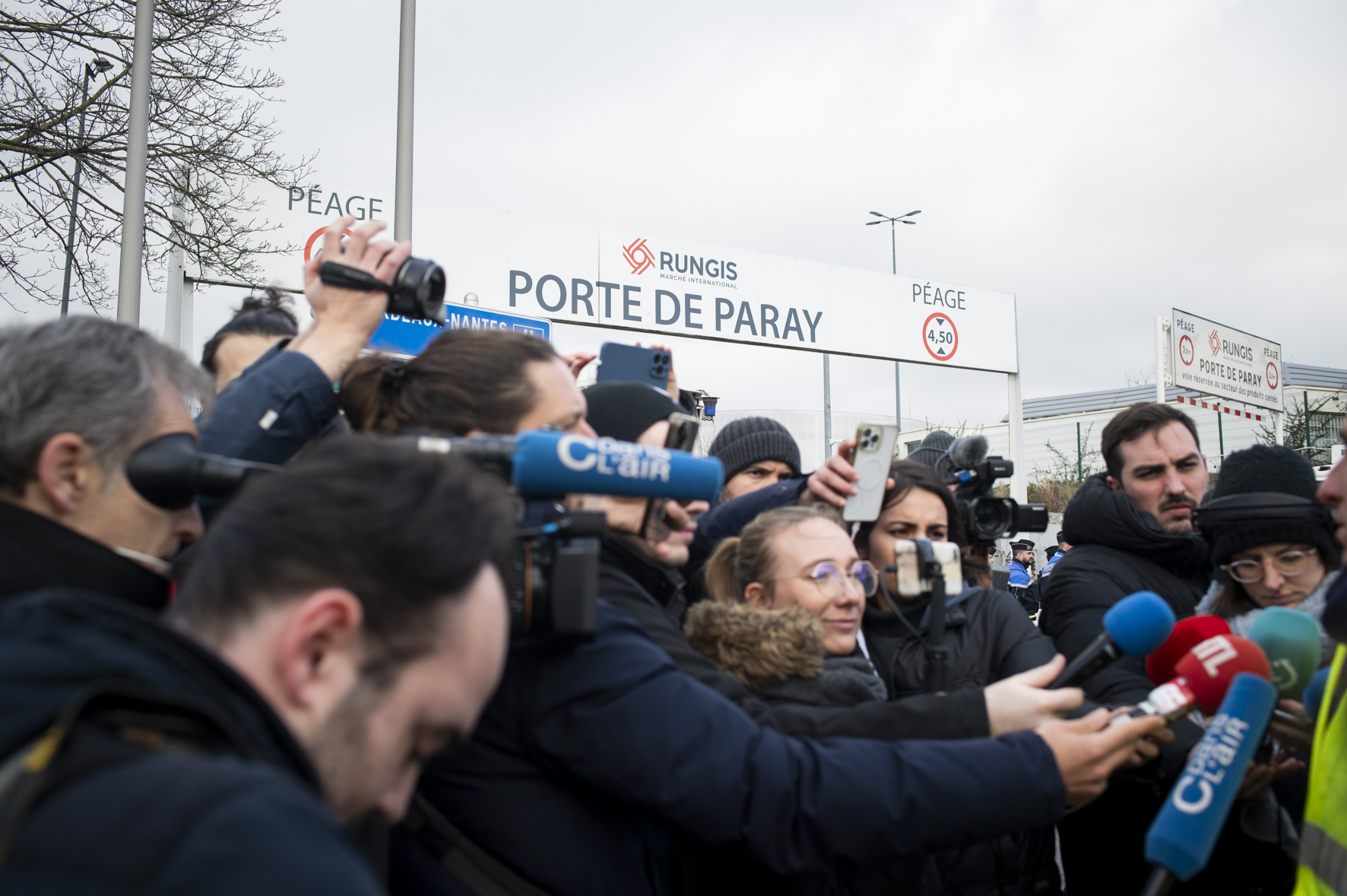 Interview d'un manifestant par de nombreux médias, sous le panneau de la porte de Paray, à Rungis