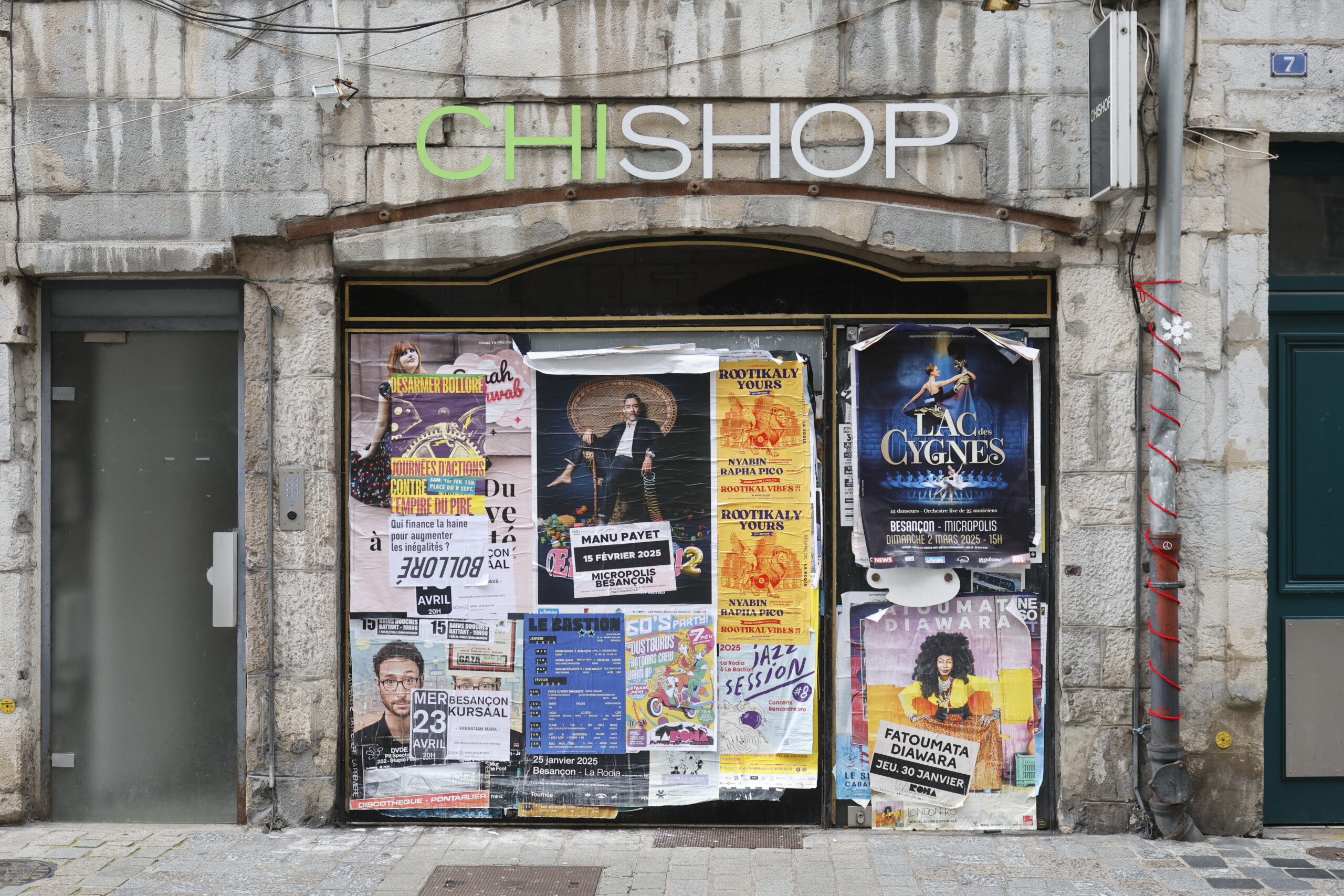 Photo de la devanture de magasin Chi Chop, fermé, porte opacifiée et vitrine entièrement recouverte d'affiches