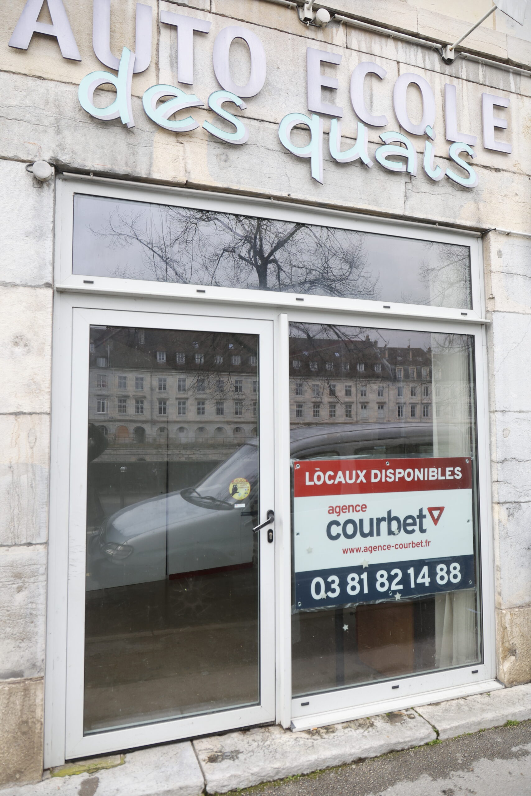 Photo de la devanture de l'auto-école des quais, fermée, avec un panneau "locaux disponibles"