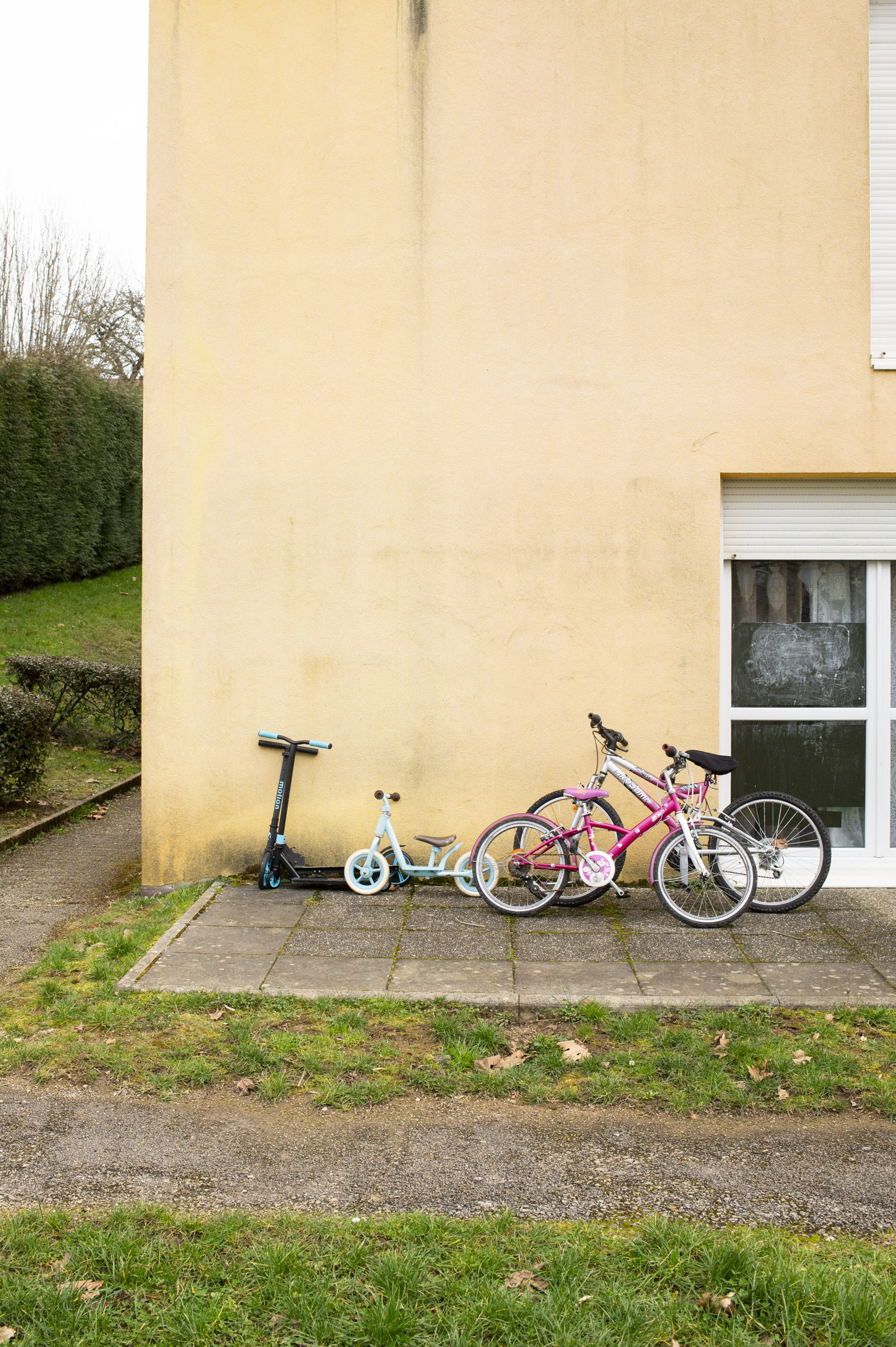 Quelques vélos posés le long d'une habitation